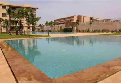 a large swimming pool with blue water at Appart très élégant avec piscine in Marrakech