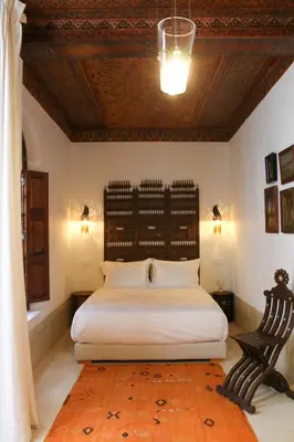 a bedroom with a large bed and a wooden ceiling at Riad El Morocco Hotel in Marrakech