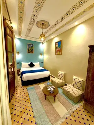 a bedroom with a bed and a couch and a table at Riad Touhfa Kasbah Marrakech in Marrakech