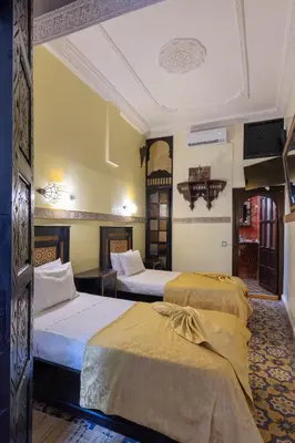a hotel room with two beds in it at Riad Arabesque in Marrakech