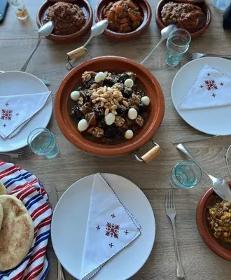 a wooden table topped with plates and a bowl of food at Riad Arabesque in Marrakech