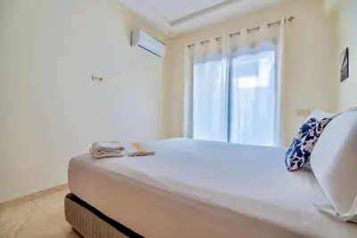 a bedroom with a large white bed with a window at Luxurious KING Bed SUITE W/POOL. Well centered. in Marrakech