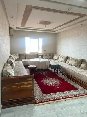 a living room with a large couch and a red rug at Appartement Marrakech Gueliz 5 Min Drive to City Center in Marrakech