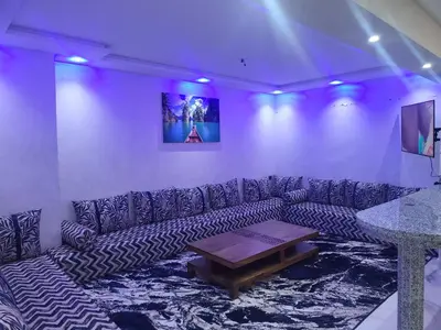 a living room with a couch and a table at Duplex+2 salles de bain à 5 min de l'aéroport in Marrakech