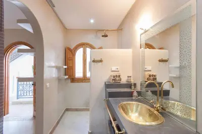 a bathroom with a sink and a mirror at Riad Melilo avec piscine chauffée in Marrakech