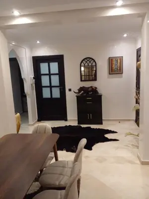 a living room with a table and a black door at Appartment Jnane Atlas in Marrakech