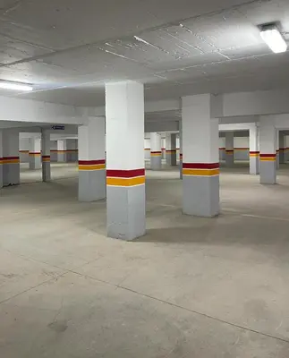 an empty parking lot with white columns in a parking garage at NOOR 5 Residence in Marrakech