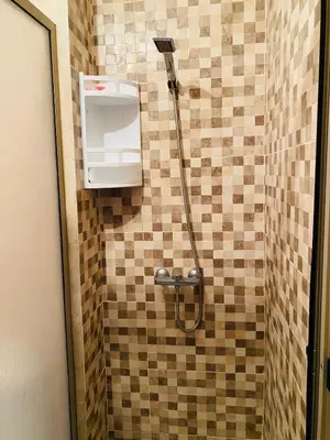 a shower in a bathroom with a tiled wall at NOOR 5 Residence in Marrakech