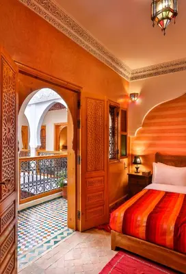 a bedroom with a bed and a balcony at Riad N 15 Zefriti in Marrakech