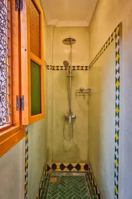 a bathroom with a shower with a glass floor at Riad N 15 Zefriti in Marrakech