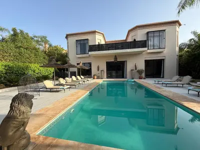 a house with a swimming pool in front of a house at Villa Jude in Marrakech