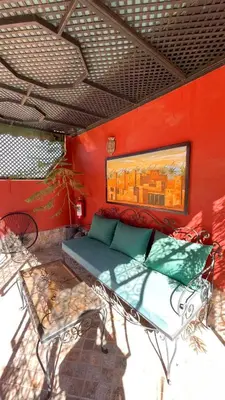 a room with a bed and a red wall at RIAD GJULJA in Marrakech