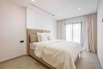 a white bedroom with a large bed and a window at New ! Logement Chic, Emplacement Idéal in Marrakech