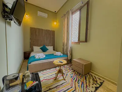 a small bedroom with a bed and a window at Riad Azia in Marrakech