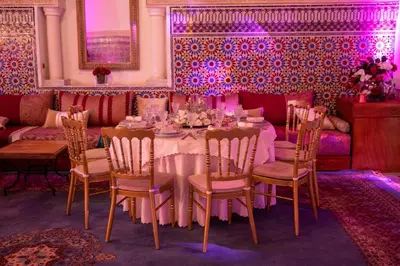 a dining room with a table and chairs and purple lighting at Nomadz Palace in Marrakech