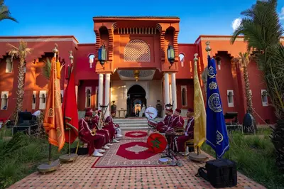 a group of people sitting in chairs in front of a building at Nomadz Palace in Marrakech