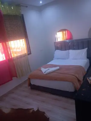 a bedroom with a large bed with two windows at Hostel Ghali & Private Rooms Gueliz in Marrakech