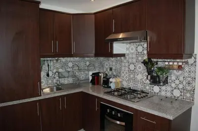 a kitchen with wooden cabinets and a stove top oven at Residence Miramas 2 D in Marrakech