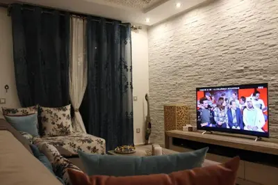 a living room with a couch and a flat screen tv at Residence Miramas 2 D in Marrakech