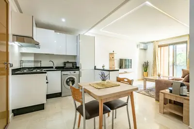 a kitchen and living room with a table and chairs at New ! Appartement Bella ,Terrasse,Fibre Obtique in Marrakech