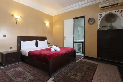 a bedroom with a large bed with a red blanket at HOTEL CTM in Marrakech