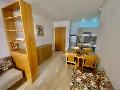 a living room with a table and a kitchen at Studio cosy au centre de Marrakech in Marrakech