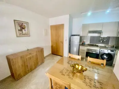 a kitchen with a wooden table and a counter top at Studio cosy au centre de Marrakech in Marrakech