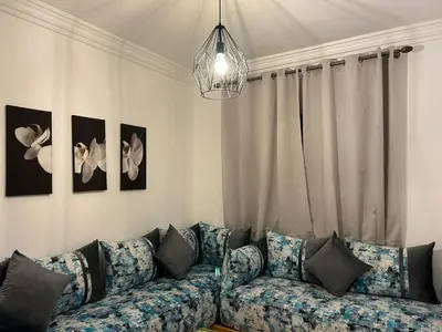 a living room with a couch and a chandelier at Entre ville et détente- les portes de Guéliz in Marrakech