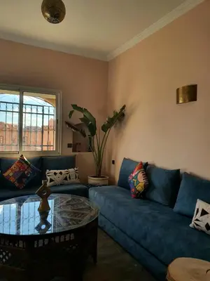 a living room with a blue couch and a glass table at Maison Mamdy Rooftop in Marrakech