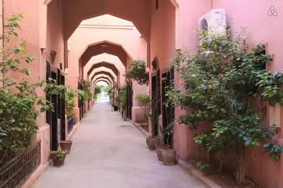 an alley with an archway with potted plants at Résidence Assiyahia avec piscine Marrakech in Marrakech