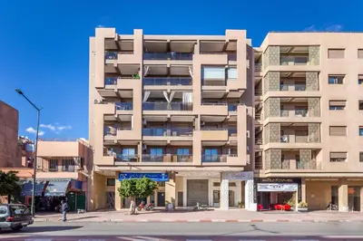 a large apartment building on a city street at Élégant Appartement , Terrasse in Marrakech