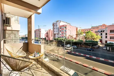 a balcony with chairs and a view of a city at Élégant Appartement , Terrasse in Marrakech