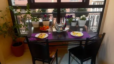 a table with plates of food on a balcony at Magnifique Appartement spacieux confort propre familial 2 chambres salon et salle a manger a 20mn a pied de place jemaa el fina 4 piscines dans espace de Golf a 12 mn en voitures l entree est gratuit pour la clientele ouvert entre 10h et 20h in Marrakech