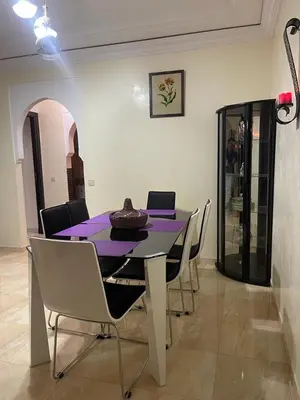 a dining room with a purple table and chairs at Magnifique Appartement spacieux confort propre familial 2 chambres salon et salle a manger a 20mn a pied de place jemaa el fina 4 piscines dans espace de Golf a 12 mn en voitures l entree est gratuit pour la clientele ouvert entre 10h et 20h in Marrakech
