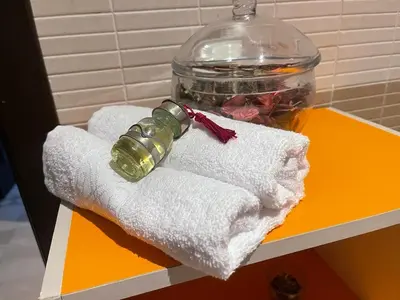 a couple of towels and a bottle on a table at Magnifique Appartement spacieux confort propre familial 2 chambres salon et salle a manger a 20mn a pied de place jemaa el fina 4 piscines dans espace de Golf a 12 mn en voitures l entree est gratuit pour la clientele ouvert entre 10h et 20h in Marrakech