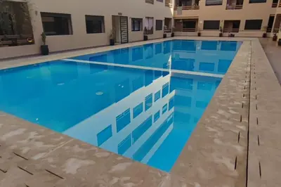 a large swimming pool with blue water at appartement piscine proche gare in Marrakech