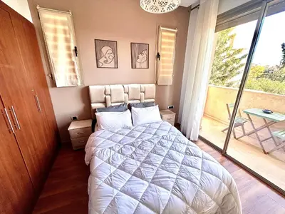 a bedroom with a bed and a large window at Havre de Paix Piscine Lagon & parc in Marrakech