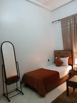 a bedroom with a bed and a mirror and a chair at Paradise house in Marrakech