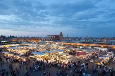 a crowd of people walking around a market at night at Gueliz Gala – Marrakech Centre in Marrakech