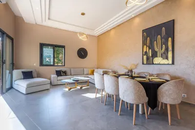 a living room with a table and chairs and a couch at Villa Dalia, Personnels et option piscine in Marrakech