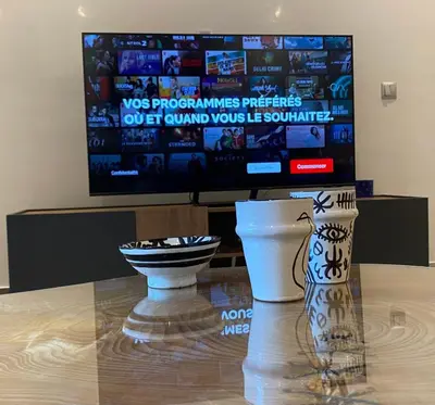 a television and a table with a vase on a table at Rooftop Pool, Atlas View, M avenue in Marrakech