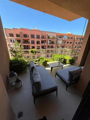a balcony with couches and tables on a building at Appartement neuf climatisé, centre Marrakech. in Marrakech