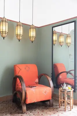 a room with two orange chairs and a table at Riad Al Uzza in Marrakech