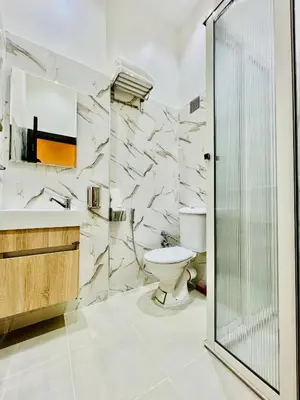 a bathroom with a toilet and a glass shower at Stay In Marrakech Blue Appartment in Marrakech