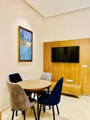 a room with a table and chairs and a television at Stay In Marrakech Blue Appartment in Marrakech