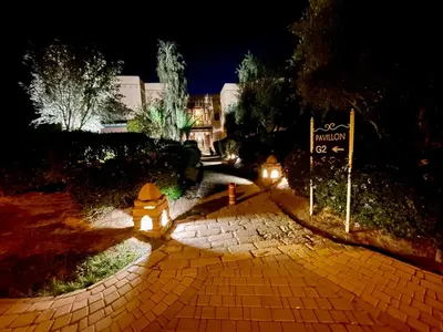 a brick walkway leading to a house at night at Les Fleurs du Bien - Marrakech in Marrakech