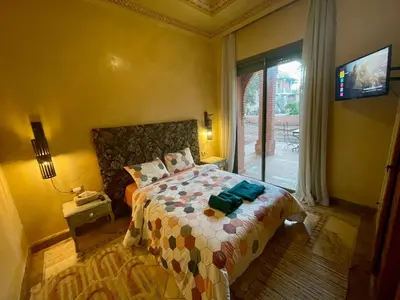 a bedroom with a bed and a window at Les Fleurs du Bien - Marrakech in Marrakech