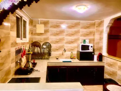 a kitchen with a sink and a microwave at Riad Kamal prés Medina Marrakech & 3 Piscines & Jacuzzi & Petit-Déjeuner in Marrakech