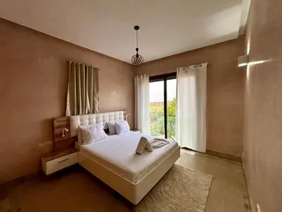 a bedroom with a large bed and a window at Private Villa BSF - Pool & Spa - Palm Golf in Marrakech