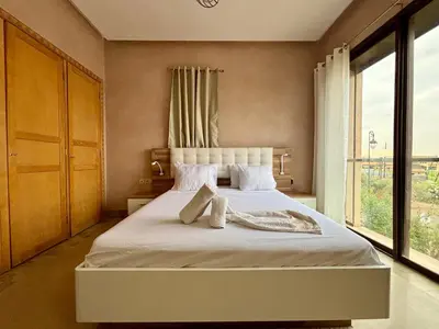 a bedroom with a white bed with a large window at Private Villa BSF - Pool & Spa - Palm Golf in Marrakech